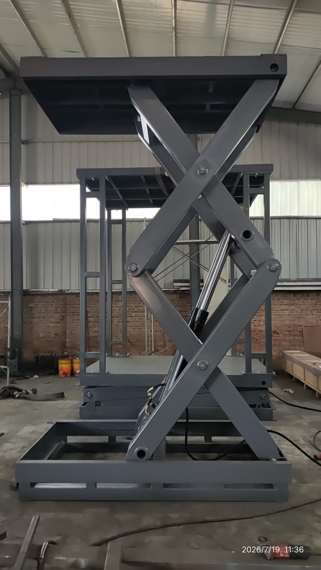 5-ton double scissor structure lift fully raised — front view showing hydraulic cylinder, scissor linkage and 2250×1250mm steel platform