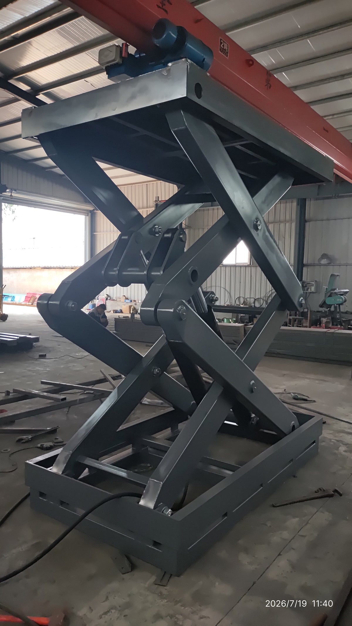 5-ton double scissor structure lift raised — wide-angle factory view showing full scissor structure height and overhead crane rail above
