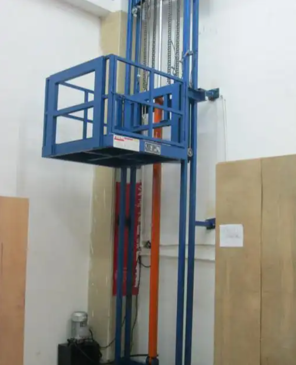 Blue guide rail cargo lift with a raised platform and steel guardrails.